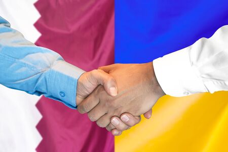 Business handshake on the background of two flags. Men handshake on the background of the Qatar and Ukraine flag. Support conceptの写真素材