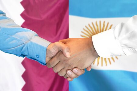 Business handshake on the background of two flags. Men handshake on the background of the Qatar and Argentina flag. Support conceptの写真素材