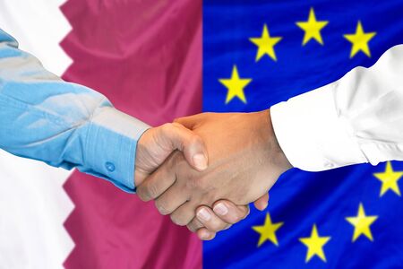 Business handshake on the background of two flags. Men handshake on the background of the Qatar and European Union flag. Support conceptの写真素材