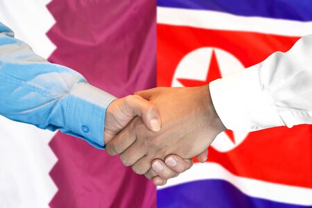 Business handshake on the background of two flags. Men handshake on the background of the Qatar and North Korea flag. Support conceptの写真素材