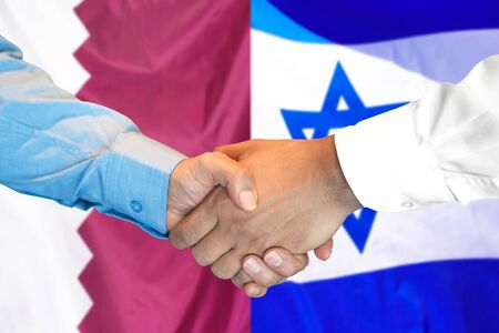 Business handshake on the background of two flags. Men handshake on the background of the Qatar and Israel flag. Support conceptの写真素材