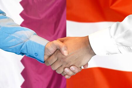 Business handshake on the background of two flags. Men handshake on the background of the Qatar and Austria flag. Support conceptの写真素材