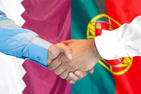 Business handshake on the background of two flags. Men handshake on the background of the Qatar and Portugal flag. Support conceptの写真素材