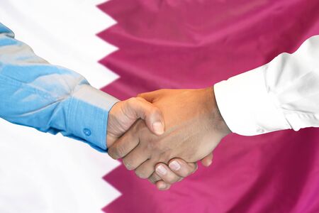 Business handshake on Qatar flag background. Men shaking hands and Qatar flag on background. Support conceptの写真素材