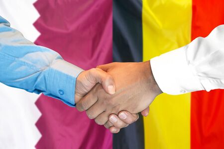 Business handshake on the background of two flags. Men handshake on the background of the Qatar and Belgium flag. Support conceptの写真素材