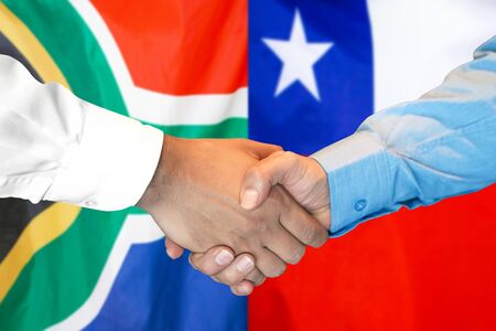 Business handshake on the background of two flags. Men handshake on the background of the South Africa and Chile flag. Support conceptの写真素材