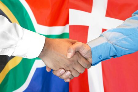 Business handshake on the background of two flags. Men handshake on the background of the South Africa and Denmark flag. Support conceptの写真素材