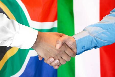 Business handshake on the background of two flags. Men handshake on the background of the South Africa and Italy flag. Support conceptの写真素材
