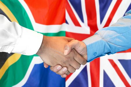 Business handshake on the background of two flags. Men handshake on the background of the South Africa and United Kingdom flag. Support conceptの写真素材