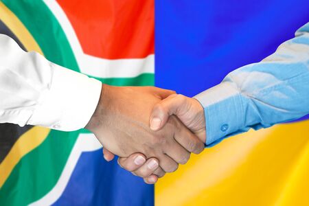 Business handshake on the background of two flags. Men handshake on the background of the South Africa and Ukraine flag. Support conceptの写真素材