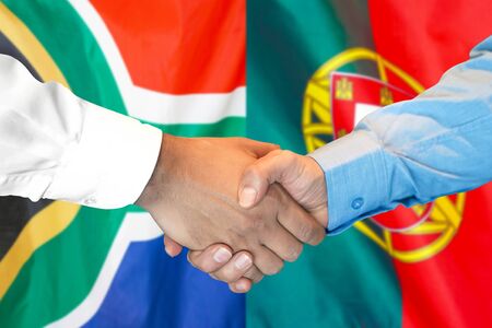 Business handshake on the background of two flags. Men handshake on the background of the South Africa and Portugal flag. Support conceptの写真素材