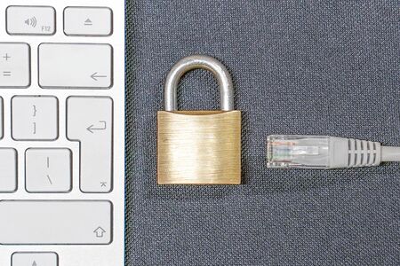 Close-up of Ñomputer keyboard, networks cable, padlock. Concept Internet blocking.