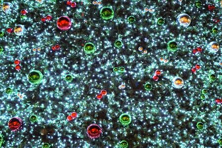 Christmas decorations on a luminous green Christmas tree close-up