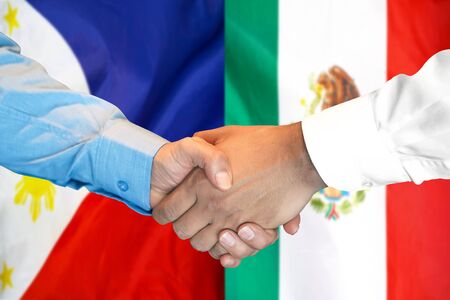 Business handshake on the background of two flags. Men handshake on the background of the Philippines and Mexico flag. Support conceptの写真素材