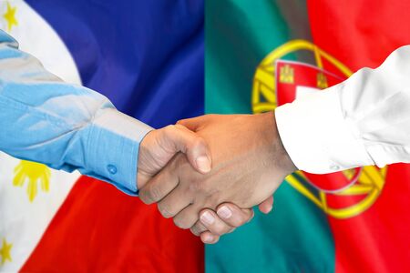 Business handshake on the background of two flags. Men handshake on the background of the Philippines and Portugal flag. Support conceptの写真素材