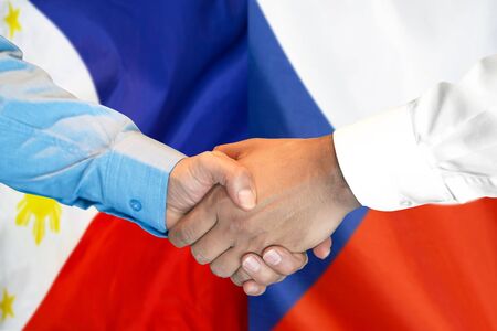 Business handshake on the background of two flags. Men handshake on the background of the Philippines and Czech Republic flag. Support conceptの写真素材