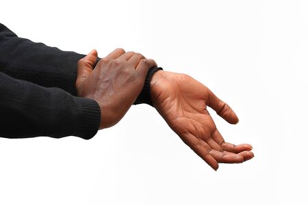 Hand pain. Closeup of african american female hands hurt isolated on a white  background. Close-up of african woman's hands with painfulfeeling in joint. Hand injury and health issues concept.                             の写真素材