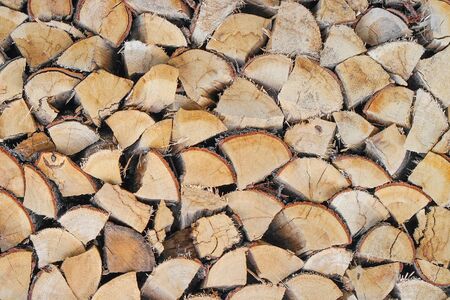 Chopped firewood combined to dry for the winter. The firewood combined in two ranks for a furnace kindling. Firewood combined in a woodpile. Textureの写真素材