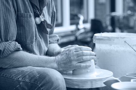 Hands of a man close-up person, creating cans or vases of gray clay. Man's hands make a clay pitcher, macro. Potter makes a pitcher.の写真素材