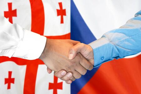 Business handshake on the background of two flags. Men handshake on the background of the Georgia and Czech Republic flag. Support conceptの写真素材