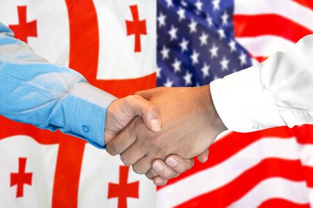 Business handshake on the background of two flags. Men handshake on the background of the Georgia and United States of America flag. Support conceptの写真素材