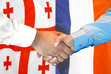 Business handshake on the background of two flags. Men handshake on the background of the Georgia and France flag. Support conceptの写真素材
