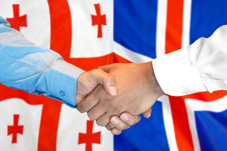 Business handshake on the background of two flags. Men handshake on the background of the Georgia and Iceland flag. Support conceptの写真素材