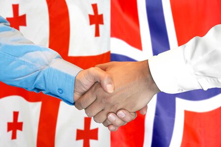 Business handshake on the background of two flags. Men handshake on the background of the Georgia and Norway flag. Support conceptの写真素材