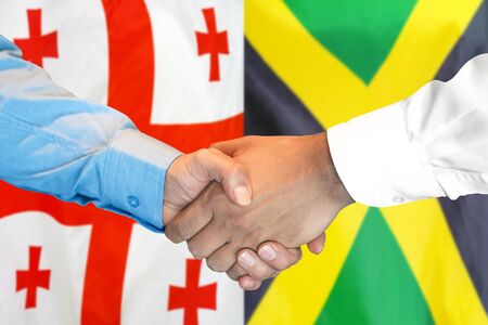 Business handshake on the background of two flags. Men handshake on the background of the Georgia and Jamaica flag. Support conceptの写真素材