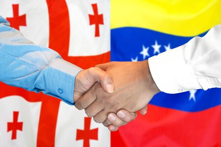 Business handshake on the background of two flags. Men handshake on the background of the Georgia and Venezuela flag. Support conceptの写真素材