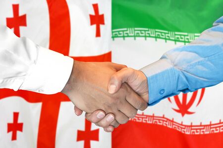 Business handshake on the background of two flags. Men handshake on the background of the Georgia and Iran flag. Support conceptの写真素材