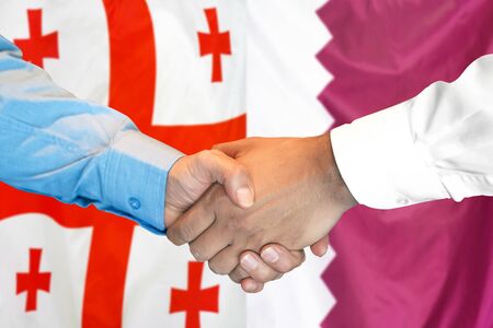 Business handshake on the background of two flags. Men handshake on the background of the Georgia and Qatar flag. Support conceptの写真素材
