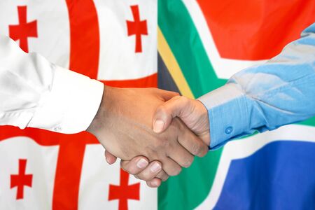 Business handshake on the background of two flags. Men handshake on the background of the Georgia and South Africa flag. Support conceptの写真素材