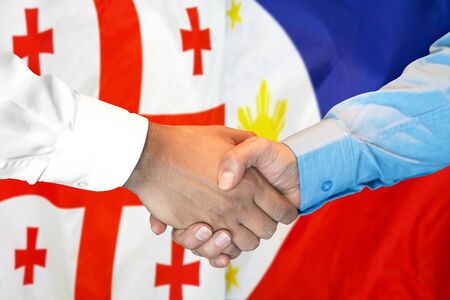 Business handshake on the background of two flags. Men handshake on the background of the Georgia and Philippines flag. Support conceptの写真素材