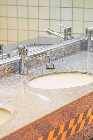 Public bathroom in the airport or restaurant, cafe. Bathroom interior sink with modern design....