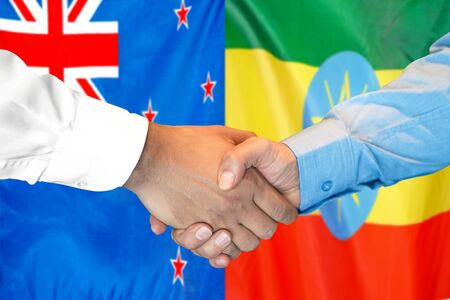 Business handshake on the background of two flags. Men handshake on the background of the New Zealand and Ethiopia flag. Support conceptの写真素材