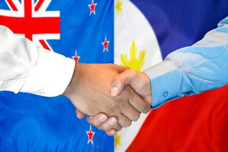 Business handshake on the background of two flags. Men handshake on the background of the New Zealand and Philippines flag. Support conceptの写真素材