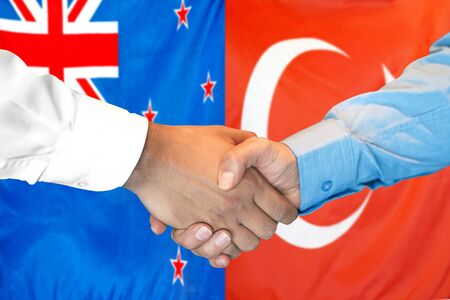 Business handshake on the background of two flags. Men handshake on the background of the New Zealand and Turkey flag. Support conceptの写真素材