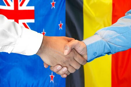 Business handshake on the background of two flags. Men handshake on the background of the New Zealand and Belgium flag. Support conceptの写真素材