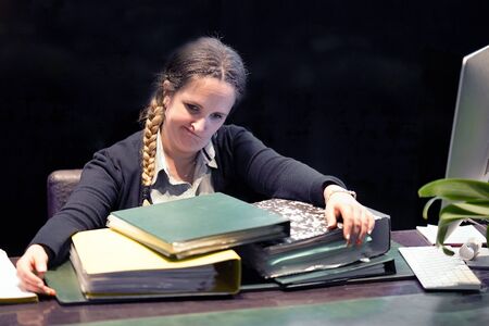 A lot of paper work in office. Office manager is distressed with a lot of paperwork in front of her. Yelling and screaming for bad results. Businesswoman in problems.の写真素材