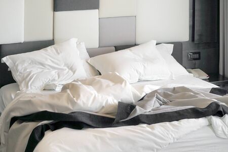 The rumpled bed in hotel. Close-up of unfinished or messy bed after funny night, sex of new married couple. Dirty bed in hotel room.の写真素材