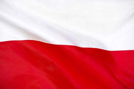 Fabric texture flag of Poland. Flag of Poland waving in the wind. Poland flag is depicted on a sports cloth fabric with many folds. Sport team banner.の写真素材