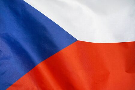 Fabric texture flag of Czech Republic. Flag of Czech Republic waving in the wind. Czech Republic flag is depicted on a sports cloth fabric with many folds. Sport team banner.の写真素材