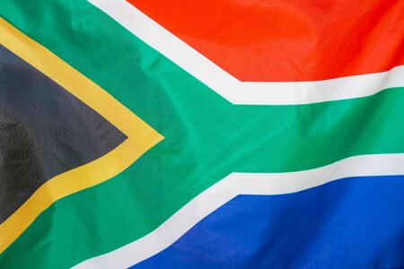 Fabric texture flag of South Africa. Flag of South Africa waving in the wind. South Africa flag is depicted on a sports cloth fabric with many folds. Sport team banner.の写真素材