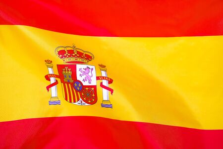 Fabric texture flag of Spain. Flag of Spain waving in the wind. Spain flag is depicted on a sports cloth fabric with many folds. Sport team banner.の写真素材