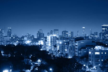 Night view of the city life. Light of the buildings shining with cool blue tones. View of night scene of Tel Aviv, Israel. Blue tone city scape. Selective focus.の写真素材