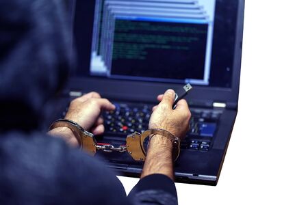 Hands of arrested hacker in handcuffed isolated on a white background. Prisoner or arrested...