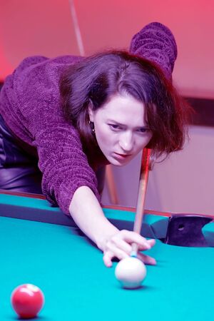 Portrait of woman playing snooker. Woman having fun with billiard. Female playing spending time on...