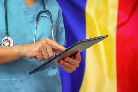 Surgeon or doctor using a digital tablet on the background of the Moldova flag. Medical equipment or medical network, technology and diagnostics in Moldova.の写真素材