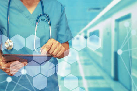 Healthcare and medicine. Surgeon or doctor using a digital tablet. Medical equipment or medical network. The doctor uses a digital tablet.の写真素材